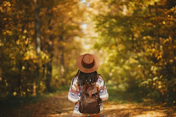 Woman walking through forest trail representing healing and personal growth