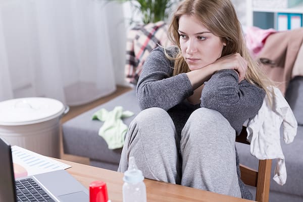 Woman sitting alone feeling anxious or emotionally overwhelmed