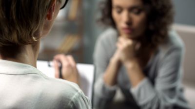 Client speaking during therapy session with counselor listening